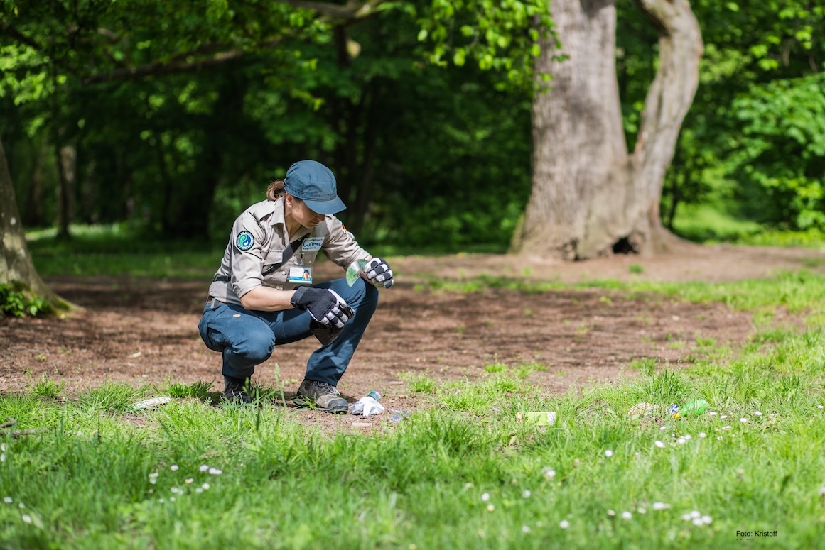 Rangerin sammelt Abfälle im Wald